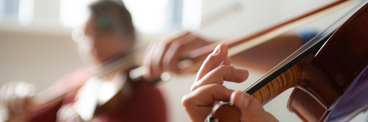 Close up of hands playing a violin