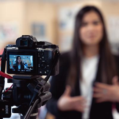 Student standing in front of video camera