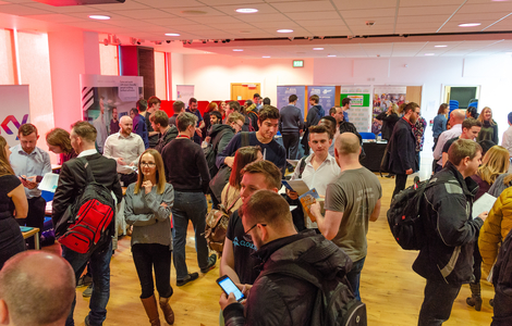 people standing in what it looks like a careers fair, talking to one another
