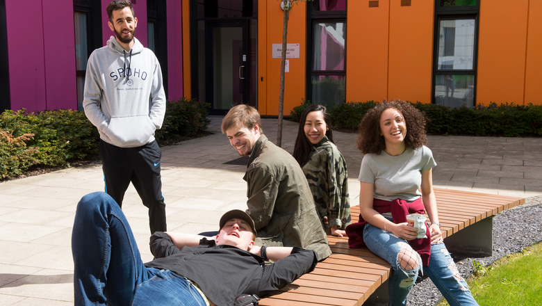 Group of students sitting on a bench outside our student accommodation at Bainfield