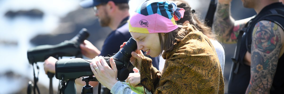 Edinburgh Napier students attending a biology field trip at St Abbs nature reserve, using telescopes to spot wildlife. 