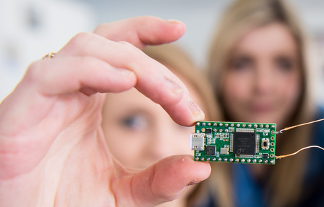 Close up of micro electronic circuit board in student's hand