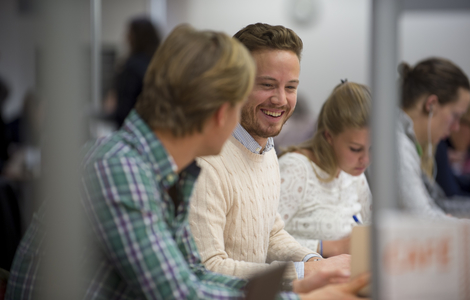 Photo of students smiling while working together