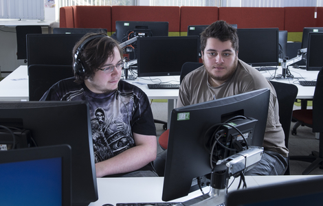 Two students working together at computer workstations