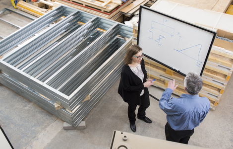 Two Engineers working in front of a whiteboard in a warehouse
