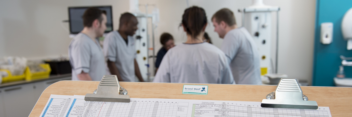 Nursing students grouped around a bed in the university's clinical skills and simulation suite