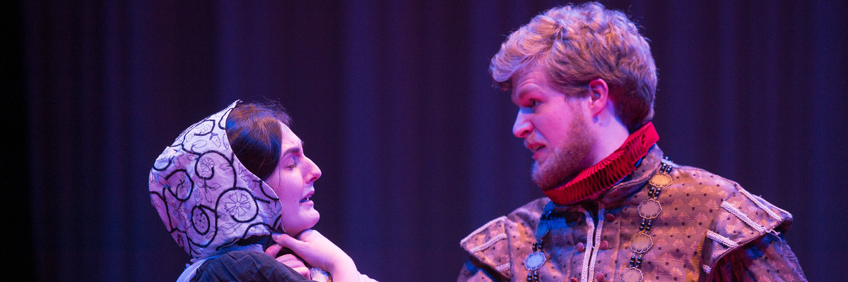 Two actors, in costume on stage