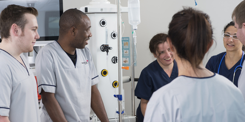 Nursing students in the clinical skills and simulation suite chatting in a group