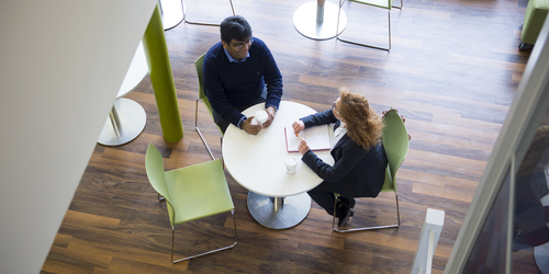 Two people talking over a coffee, at the Apex Cafe in Merchiston