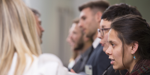 People talking at a conference, whilst standing in two rows opposite each other