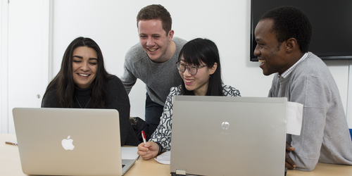 students surrounding a laptop