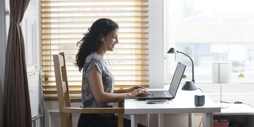Side profile of a Student at a desk using laptop
