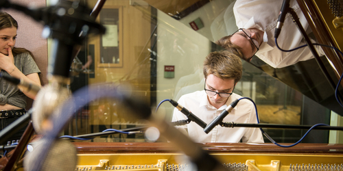 Student playing the piano in a music studio