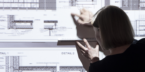 Person pointing at projected building plans