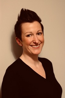 Kate Buchan smiling at the camera in front of a plain white background