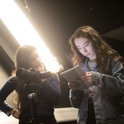 Two people working with a camera and tablet
