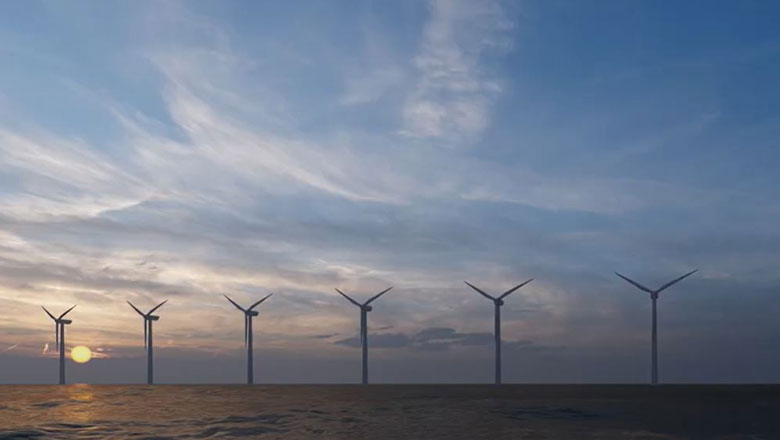 A row of wind turbines in the sea at sunset