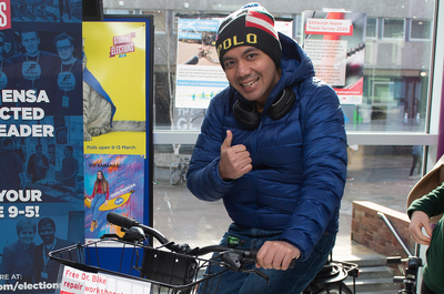 A student cycling on the smoothie bike at the Sustainable Travel Fair