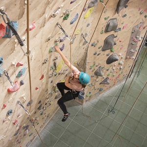 A photograph of a climber scaling a climbing wall
