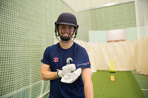 A batsman shows the Edinburgh Napier logo