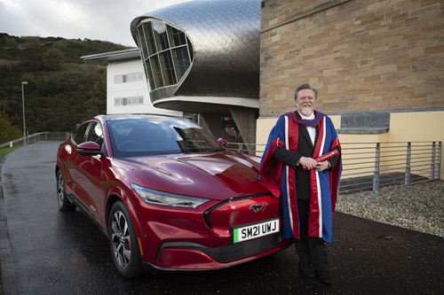 Honorary graduate Moray Callum with Ford Mustang Mach E