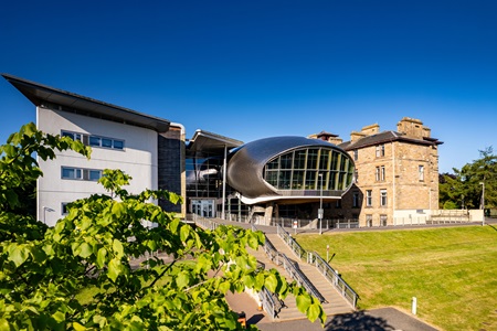 Edinburgh Napier University's Criaglockhart campus set against a cloudless blue sky