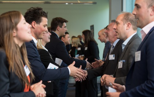 Two lines of people shaking hands with one another
