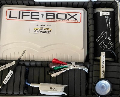 Black compartmentalised box containing white LifeBox and additional equipment such as stethoscope, ECG leads and blood pressure monitor 
