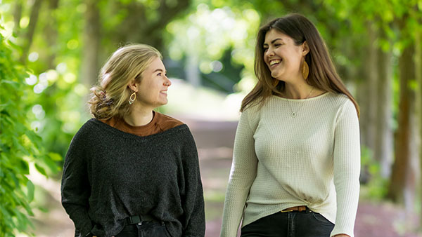 two students walking in nature and talking