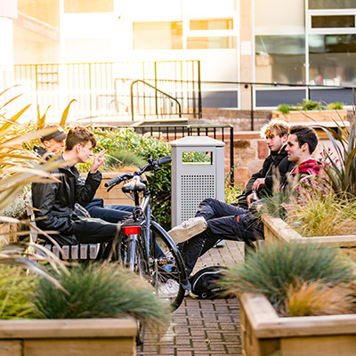 Students relaxing amongst the greenery in front of Merchiston tower